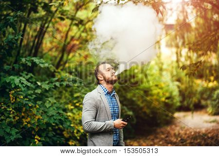 Men With Beard Smoking Electronic Cigarette Outdoor
