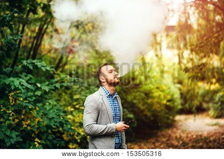 Men With Beard Smoking Electronic Cigarette Outdoor