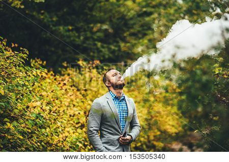 Men With Beard Smoking Electronic Cigarette Outdoor