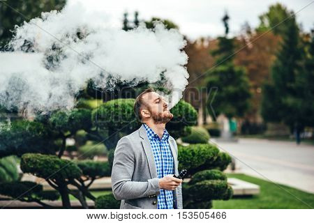 Men With Beard Smoking Electronic Cigarette Outdoor
