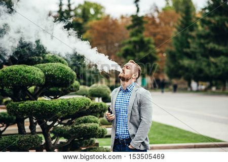 Men With Beard Smoking Electronic Cigarette Outdoor