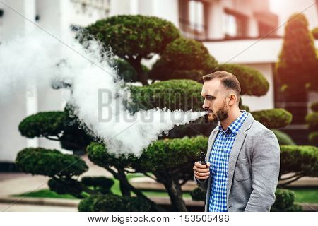 Men With Beard Smoking Electronic Cigarette Outdoor