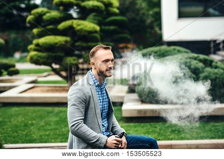 Men With Beard Smoking Electronic Cigarette Outdoor