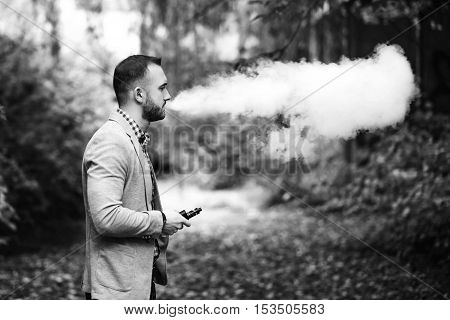 Men With Beard Smoking Electronic Cigarette Outdoor