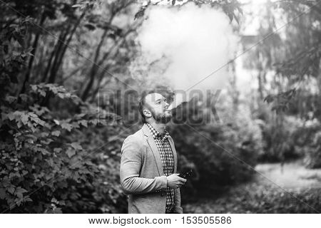 Men With Beard Smoking Electronic Cigarette Outdoor
