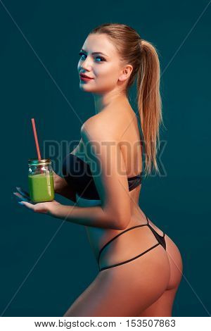 Beauty woman holding a jar tumbler mug with green smoothie drink