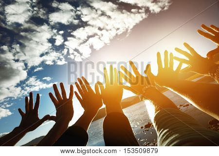 Friendship team concept with lots of hands reaching to the sun