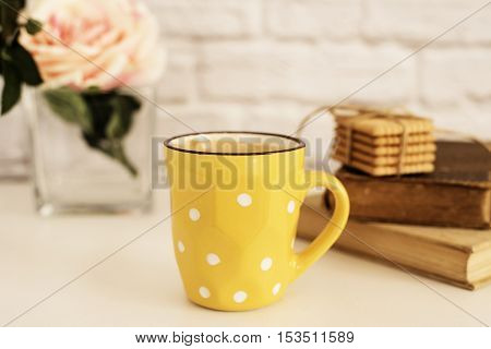 Coffee Cup, Cappuccino, Latte, Old Books, Cookies And Rose On White Table. Gray Brick Wall. Leisure