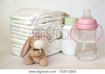 accessories for baby diapers on white background banny a bottle of water cream