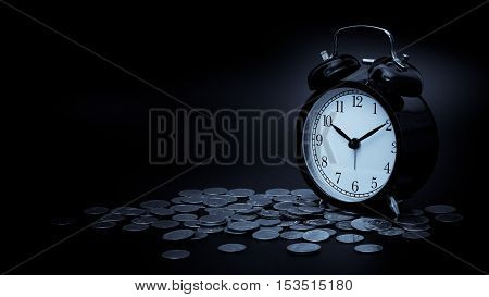 saving time Alarm clock with coins isolated on black background. with vintage filter