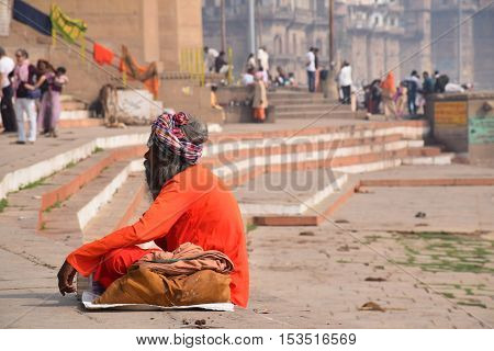 VARANASI, UTTAR PRADESH, INDIA - FEBRUARY 17, 2016 - Unidentified indian man sitting and meditating on the ghats of Varanasi after sunset