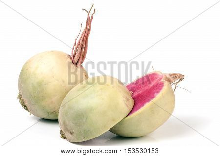 One whole and sliced watermelon radish isolated on white background.