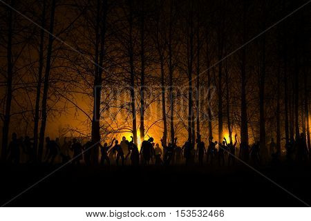 crowd of hungry zombies in the woods. Silhouettes of scary zombies walking in the forest at night. yellow Acid variant