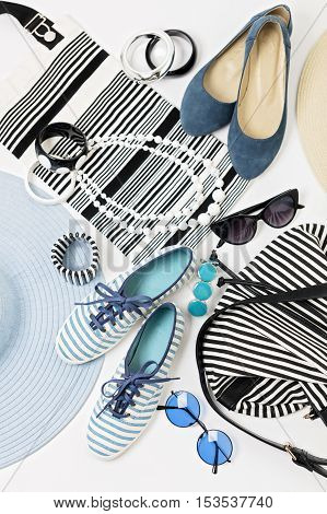 Fashion accessories in black and white and blue colors - hat clothing shoes and bag bracelets and glasses.