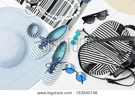 Fashion accessories in black and white and blue colors - hat clothing shoes and bag bracelets and glasses.