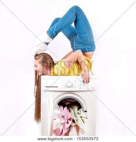 The young beautiful girl with long hair sitting on the bridge did the washing machine. Advertisement washing machine