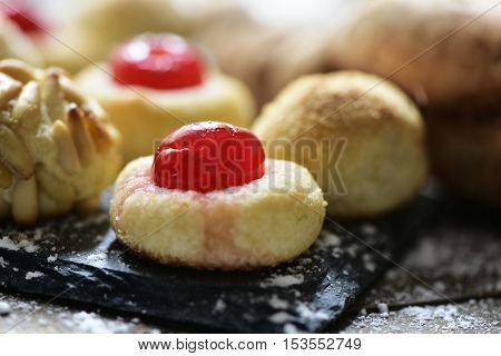 closeup of some homemade panellets, typical confection eaten in All Saints Day in Catalonia, Spain, on a rustic kitchen table