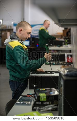 Saint-Petersburg Russia - October 19 2016: The production line of a small business computer assembly. Engineer a production line with a screwdriver in his hands