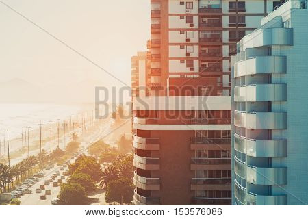 Street of Rio de Janeiro near beach and ocean in luxury Barra district with buildings and cars on a hot sunny summer day sunset or dawn view from top vintage colour filter