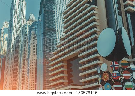 Row of blue and teal contemporary modern business and residential skyscrapers in Dubai on a sunny summer day
