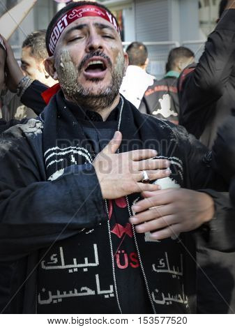 Istanbul Turkey - October 11 2016: Shia Muslim men shout Islamic slogans as they mourn during an Ashura procession. Muslims worldwide marks Ashura Istanbul Shiite community. Turkish Shia Muslims mourning for Imam Hussain. Caferis take part in a mourning p