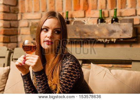 Woman Tasting Wine In Rural Cottage Interior