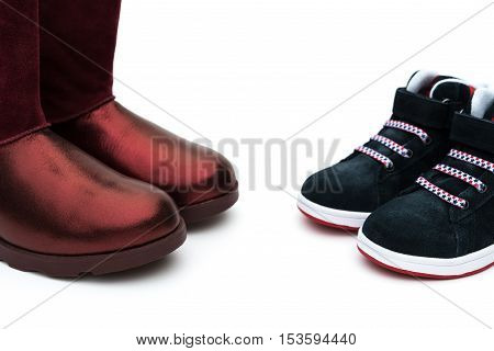 black shoes for son and red ones for mom on white as filiation concept