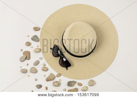 Fashion accessories - hat sunglasses and bracelets. Marine concept sea shells and sea pebbles.