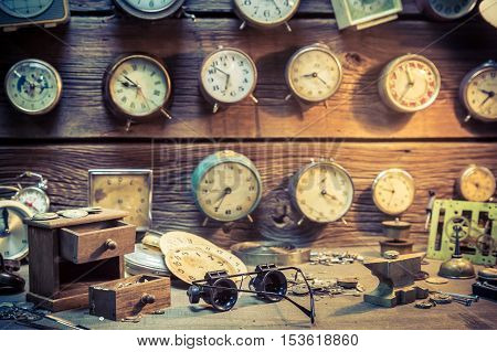 Old watchmaker's room full of clocks on old wooden table