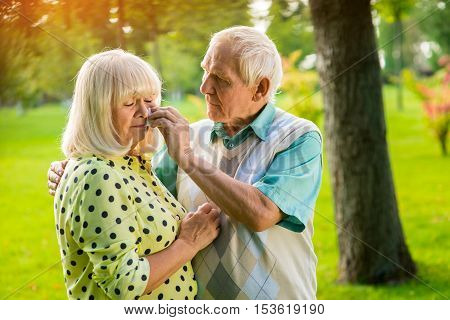 Sad elderly couple. Man wiping tears of woman. Grief in the family. Don't lose hope, my love.