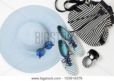Fashion accessories in blue colors - hat shoes and bag bracelets and glasses.