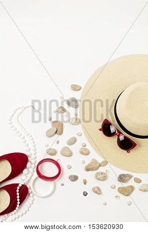 Fashion accessories - hat sunglasses and bracelets. Marine concept sea shells and sea pebbles.