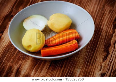 Poseshenie vegetables to prepare vegetable soup with spices on a light plate .