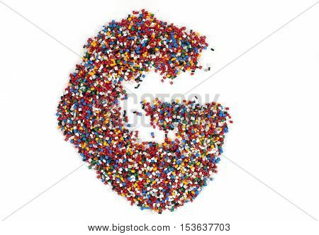 G shaped colorful plastic polymer granules on white background