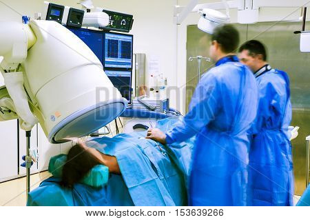 Non invasive heart procedure in hospital surgery with two doctors and a patient under a scanner.