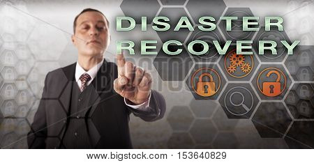 Experienced corporate manager pressing DISASTER RECOVERY on an interactive screen. Information technology concept for resuming normal business activities after disruption of business continuity.