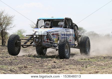 Sun City, South Africa - OCTOBER 1, 2016: Front view of white Chenowth rally car racing through bush at Sun City 450 Rally Racing event, Sun City, South Africa