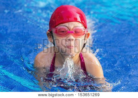 Child Swimming Breaststroke In Swimming Pool