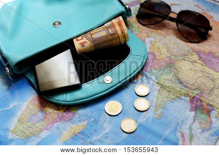 Some staff for travel. Money glasses bag phone coins are located on the intrenational map.