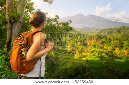 Woman traveler looking at volcano Rinjani island Lombok. Indonesia.Young backpacker traveling along mountains happy female walking discovering world summer vacation concept