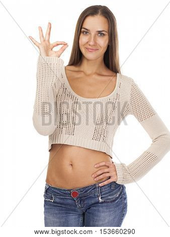 Portrait of a beautiful young brunette woman showing okey, isolated on white background