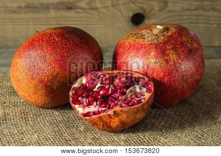 Still life with fresh ripe grenades on an old wooden table.