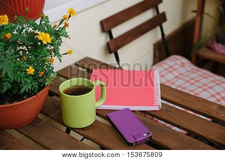 home office on the terrace, close-up, table, notebook, coffee mug