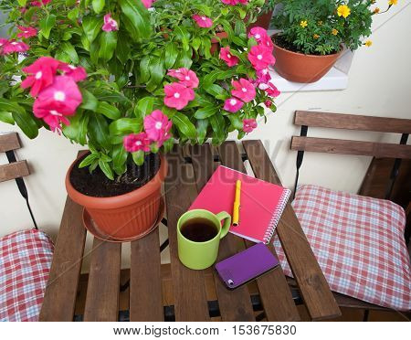 home office on the terrace, close-up, table, notebook, coffee mug