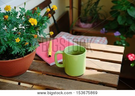 home office on the terrace, close-up, table, notebook, coffee mug