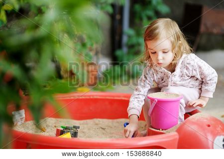 Little Girl Playing In A Sandbox