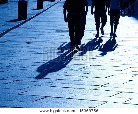 Quattro ombre di persone a piedi. Tinta blu.