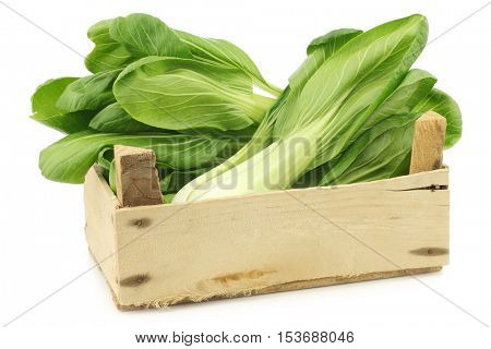 fresh Shanghai (small) paksoi in a wooden crate on a white background