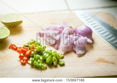 Red Onion Chopped, Chilli Chopped  And Lemon On Wooden Chopping Board