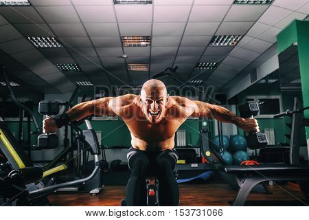 Bodybuider demonstrate crossover exercises in the gym